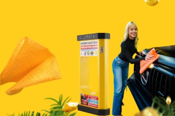 Yellow Rulomatik car drying towel vending machine beside a car